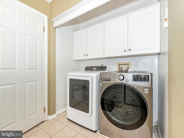 laundry area with cabinets, washer and dryer, and light tile patterned floors