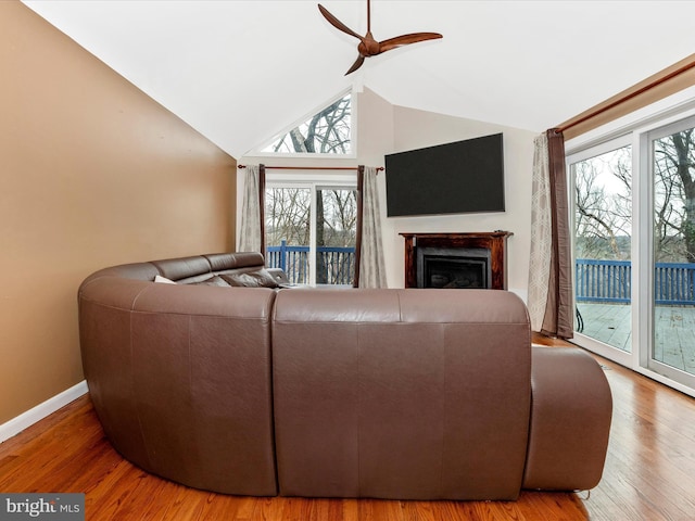 living room with ceiling fan, wood-type flooring, and high vaulted ceiling