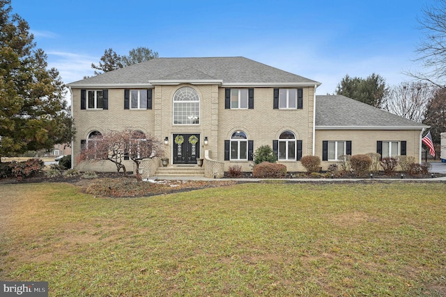 colonial inspired home featuring a front lawn