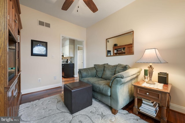 living room with ceiling fan and dark hardwood / wood-style flooring