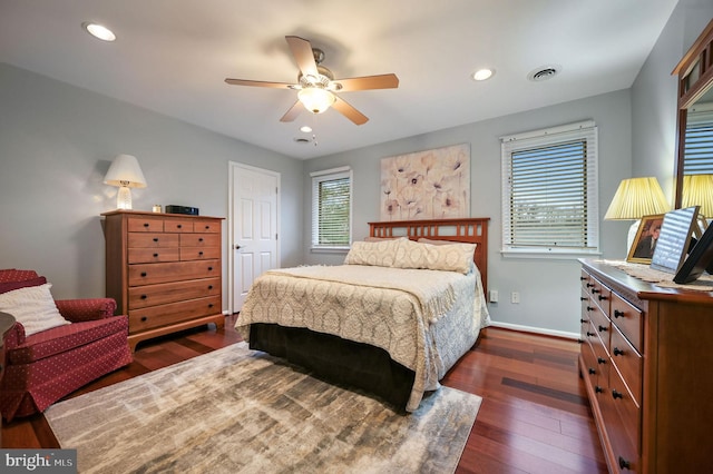 bedroom with multiple windows, dark wood-type flooring, and ceiling fan