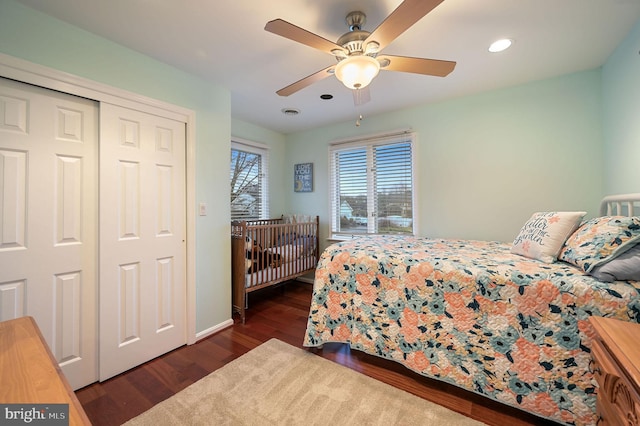 bedroom featuring dark wood-type flooring, ceiling fan, and a closet