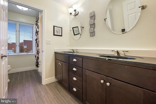 bathroom with hardwood / wood-style flooring, vanity, and toilet