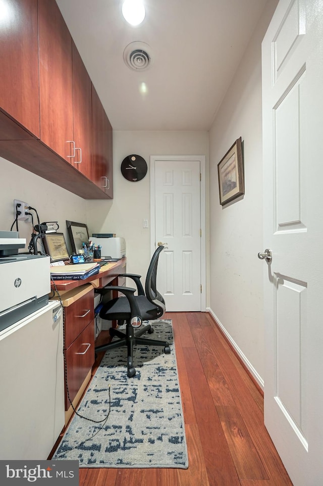 home office with dark wood-type flooring