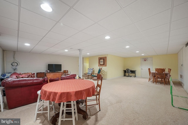 dining area with a paneled ceiling and light colored carpet