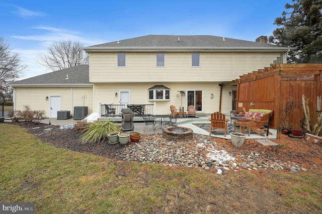 rear view of house with central AC unit, a patio area, a deck, and an outdoor fire pit