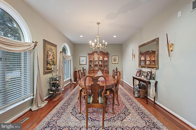 dining area featuring dark hardwood / wood-style flooring and a chandelier