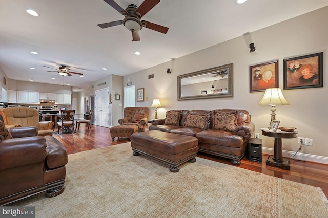 living room featuring dark wood-type flooring and ceiling fan