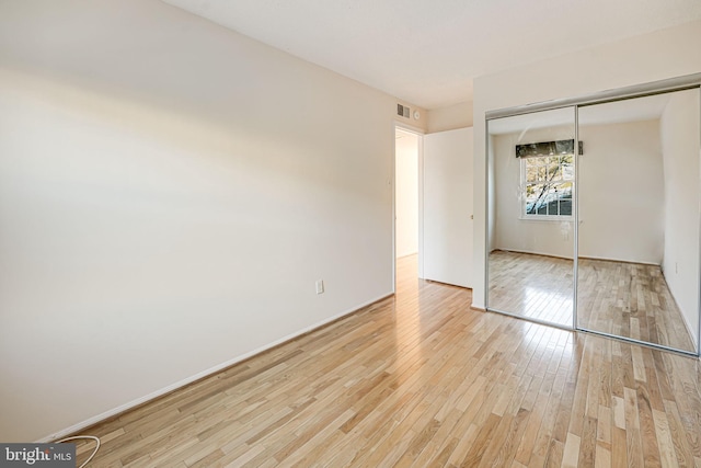 unfurnished bedroom featuring a closet and light wood-type flooring