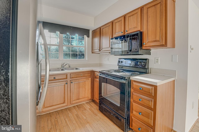 kitchen with sink, light wood-type flooring, and black appliances