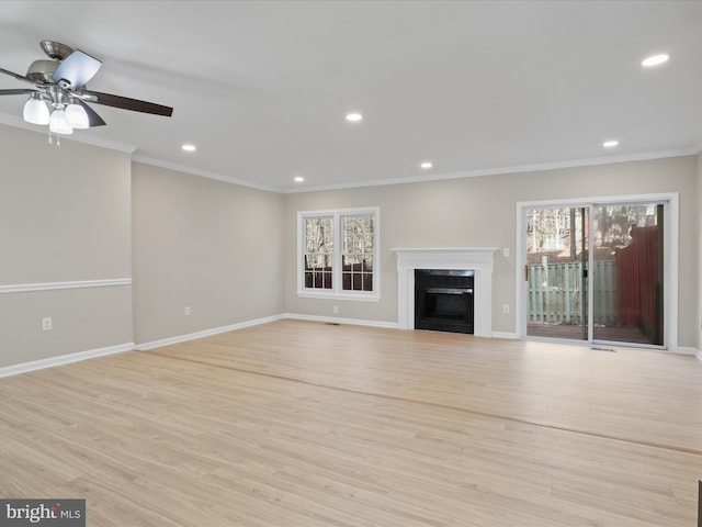 unfurnished living room featuring crown molding, plenty of natural light, ceiling fan, and light wood-type flooring