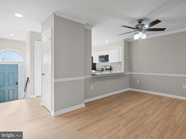 kitchen with white cabinetry, light hardwood / wood-style flooring, stainless steel electric range, kitchen peninsula, and ceiling fan