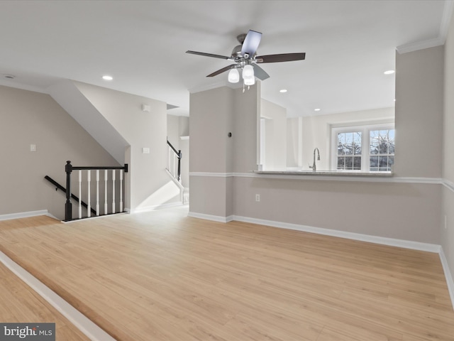 empty room featuring ceiling fan, lofted ceiling, sink, and light hardwood / wood-style floors