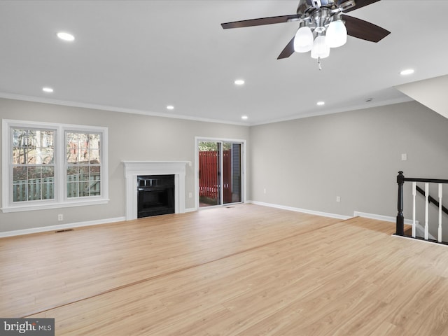 unfurnished living room featuring ceiling fan, ornamental molding, a healthy amount of sunlight, and light hardwood / wood-style flooring