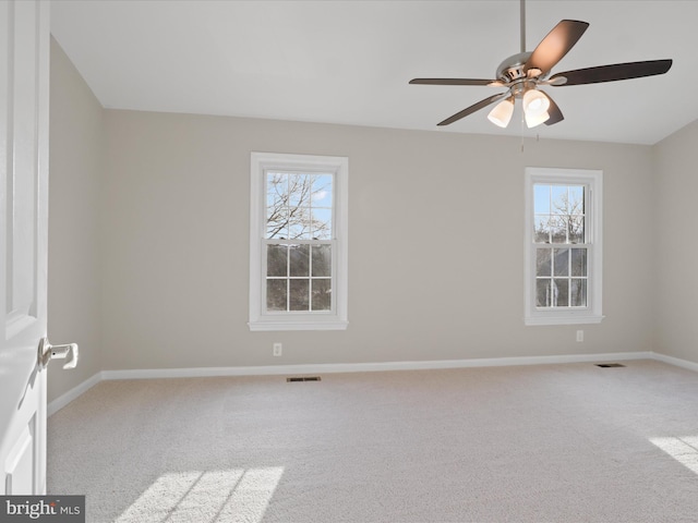 carpeted spare room featuring ceiling fan