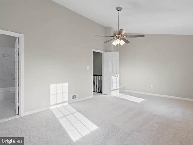 carpeted spare room with ceiling fan and high vaulted ceiling