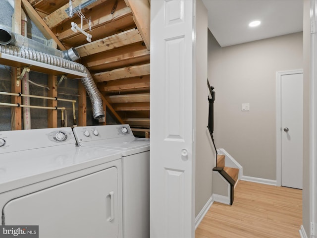 clothes washing area featuring washing machine and dryer and light wood-type flooring