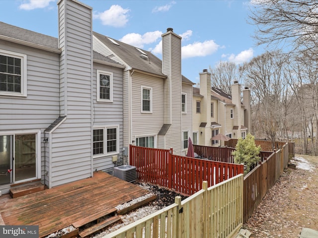 back of house with cooling unit and a deck