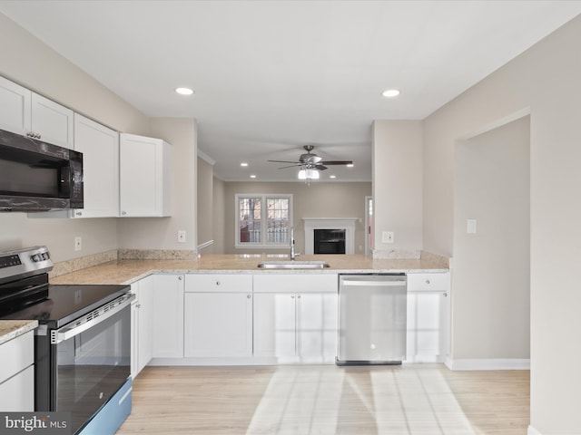 kitchen with appliances with stainless steel finishes, sink, light hardwood / wood-style flooring, and white cabinets