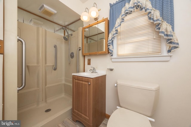 bathroom with toilet, vanity, and walk in shower