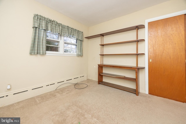 unfurnished bedroom with a baseboard radiator and carpet