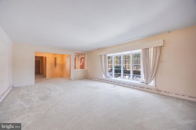 unfurnished room with a baseboard heating unit and light colored carpet