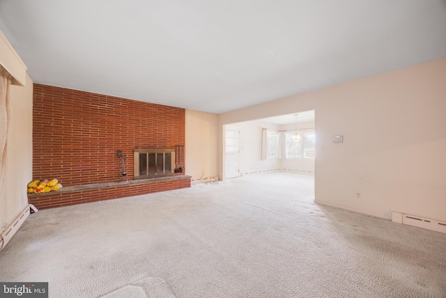 unfurnished living room featuring a baseboard heating unit, brick wall, a brick fireplace, and carpet