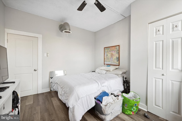 bedroom with ceiling fan, dark hardwood / wood-style floors, a closet, and a textured ceiling