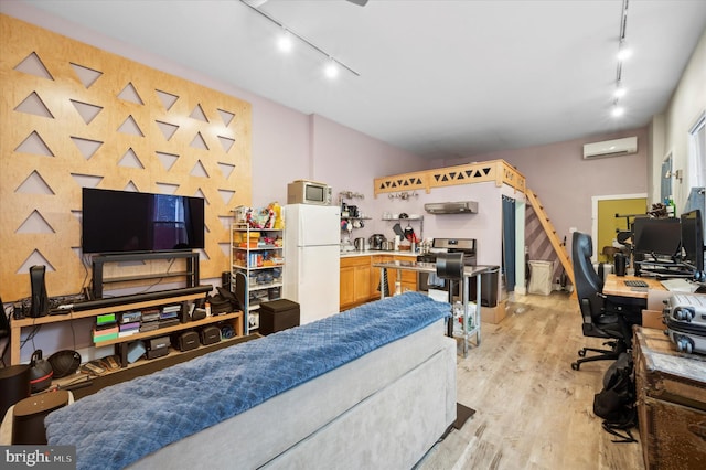 interior space with rail lighting, a wall mounted AC, and light wood-type flooring