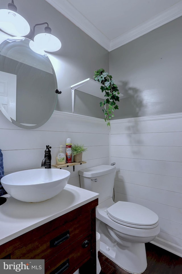 bathroom with vanity, hardwood / wood-style flooring, ornamental molding, and toilet