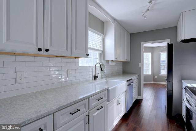 kitchen with white cabinetry, sink, dark hardwood / wood-style flooring, stainless steel appliances, and light stone countertops