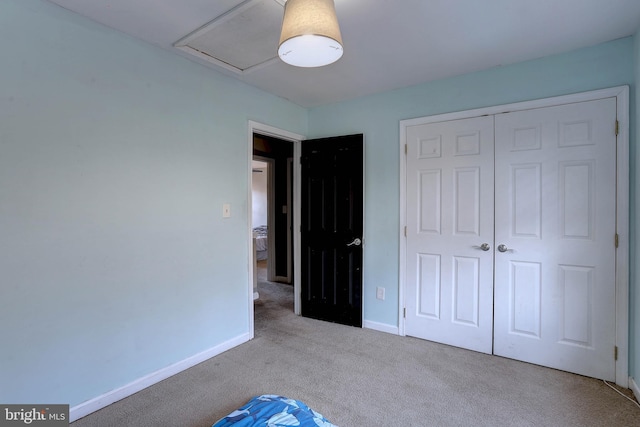 unfurnished bedroom with light colored carpet and a closet