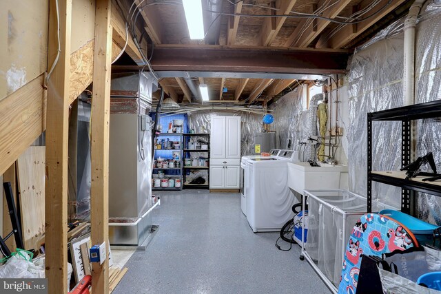 basement with water heater, sink, and washer and clothes dryer