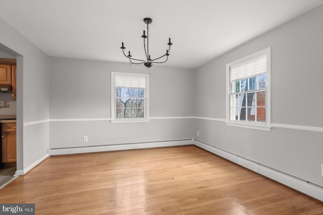 unfurnished dining area featuring baseboard heating, plenty of natural light, a chandelier, and light wood-type flooring