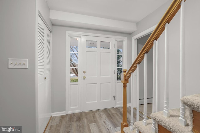 entrance foyer featuring a baseboard radiator and light hardwood / wood-style flooring