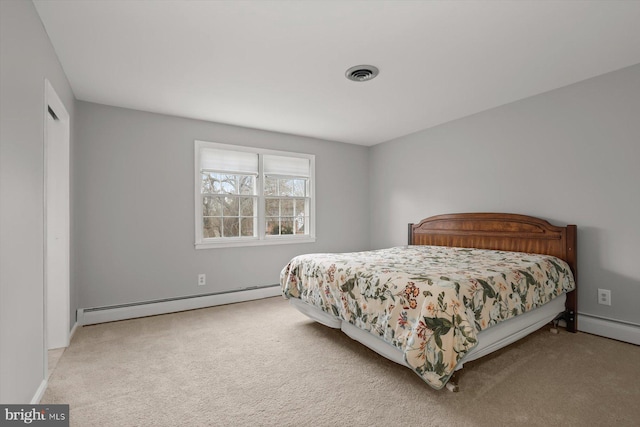 bedroom featuring a baseboard heating unit, light colored carpet, and a closet