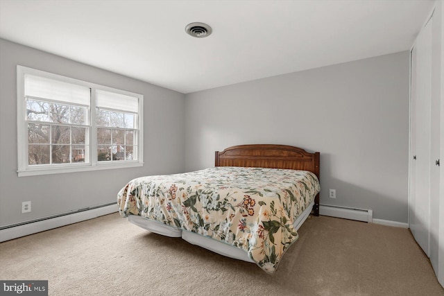 carpeted bedroom featuring a baseboard heating unit