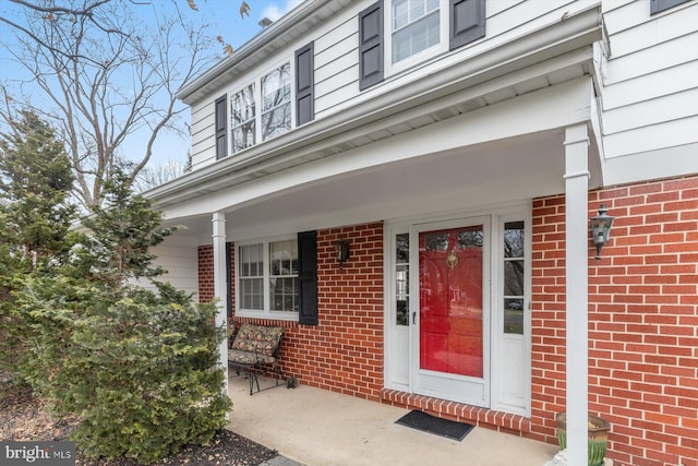 view of exterior entry featuring covered porch