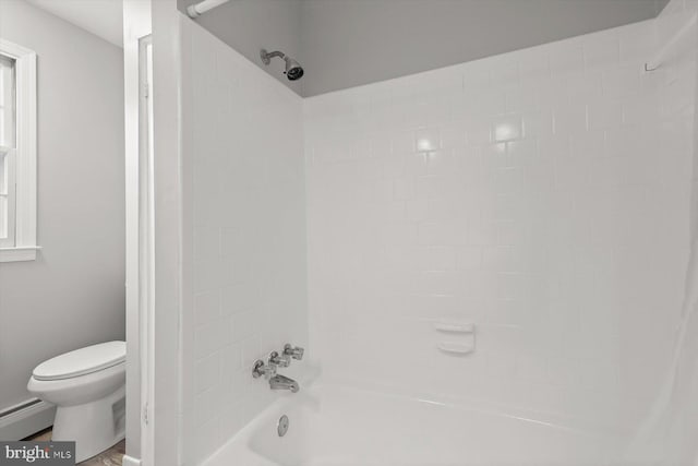 bathroom featuring tiled shower / bath, toilet, and baseboard heating