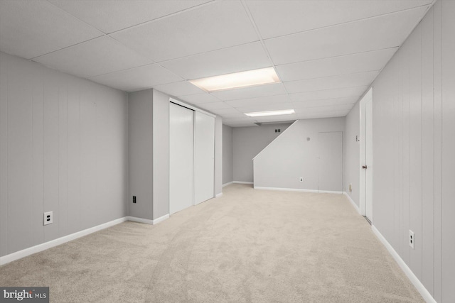 basement with light carpet and a drop ceiling