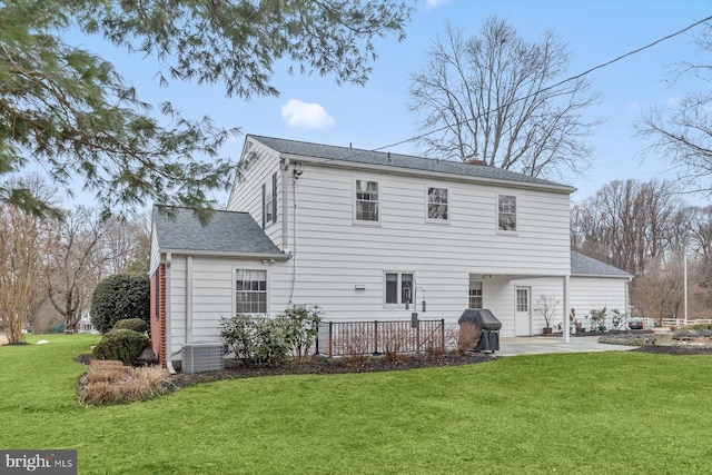 rear view of house with cooling unit, a yard, and a patio