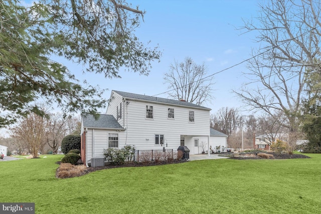 back of property featuring a patio and a lawn