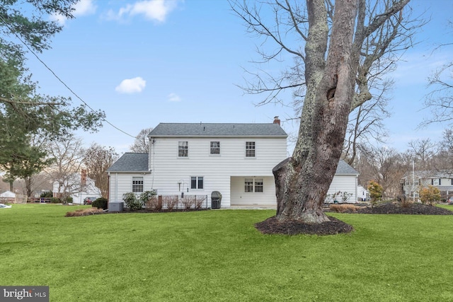 rear view of house featuring a yard and central AC unit