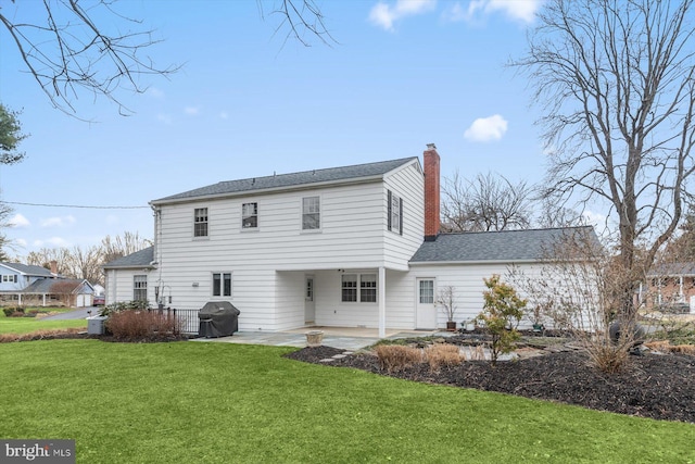 rear view of property featuring a lawn and a patio area