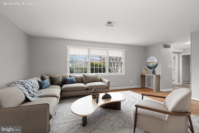 living room with baseboard heating and light wood-type flooring