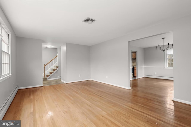 empty room featuring a baseboard radiator, hardwood / wood-style floors, and an inviting chandelier