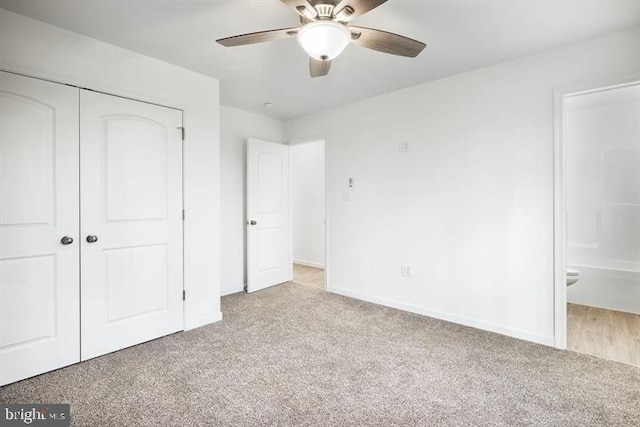 unfurnished bedroom with light carpet, a closet, ceiling fan, and ensuite bathroom