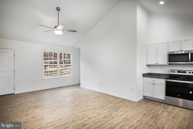 kitchen featuring stainless steel appliances, high vaulted ceiling, white cabinets, and light hardwood / wood-style floors