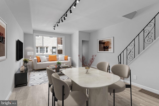 dining area featuring track lighting and light wood-type flooring