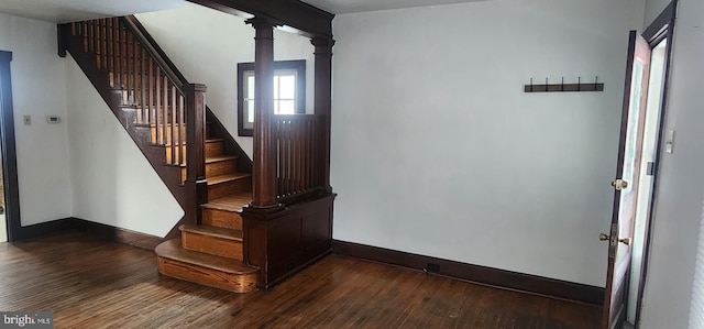 entrance foyer with ornate columns and dark hardwood / wood-style floors